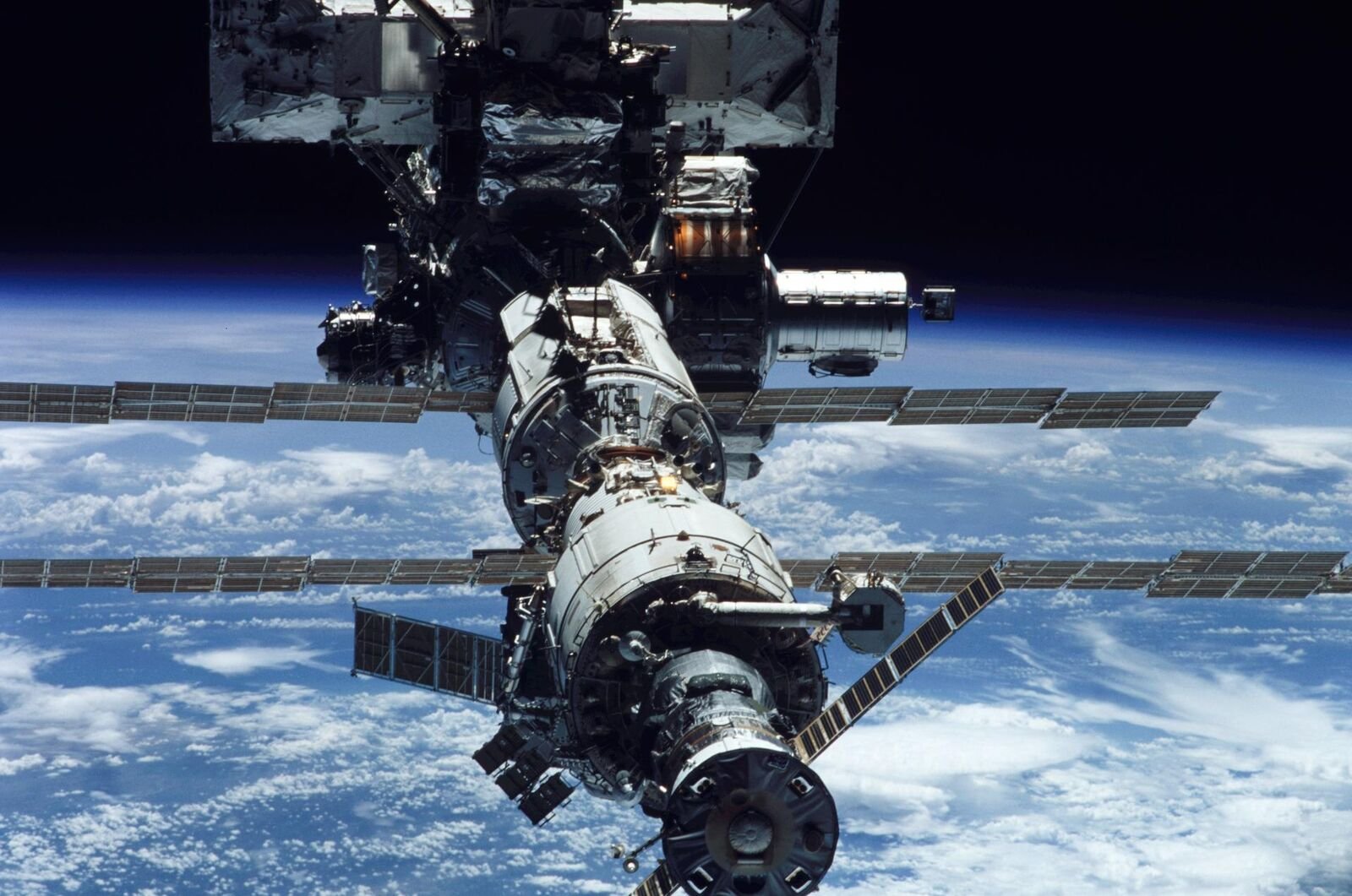 A Estação Espacial Internacional com painéis solares, sobre a Terra azul