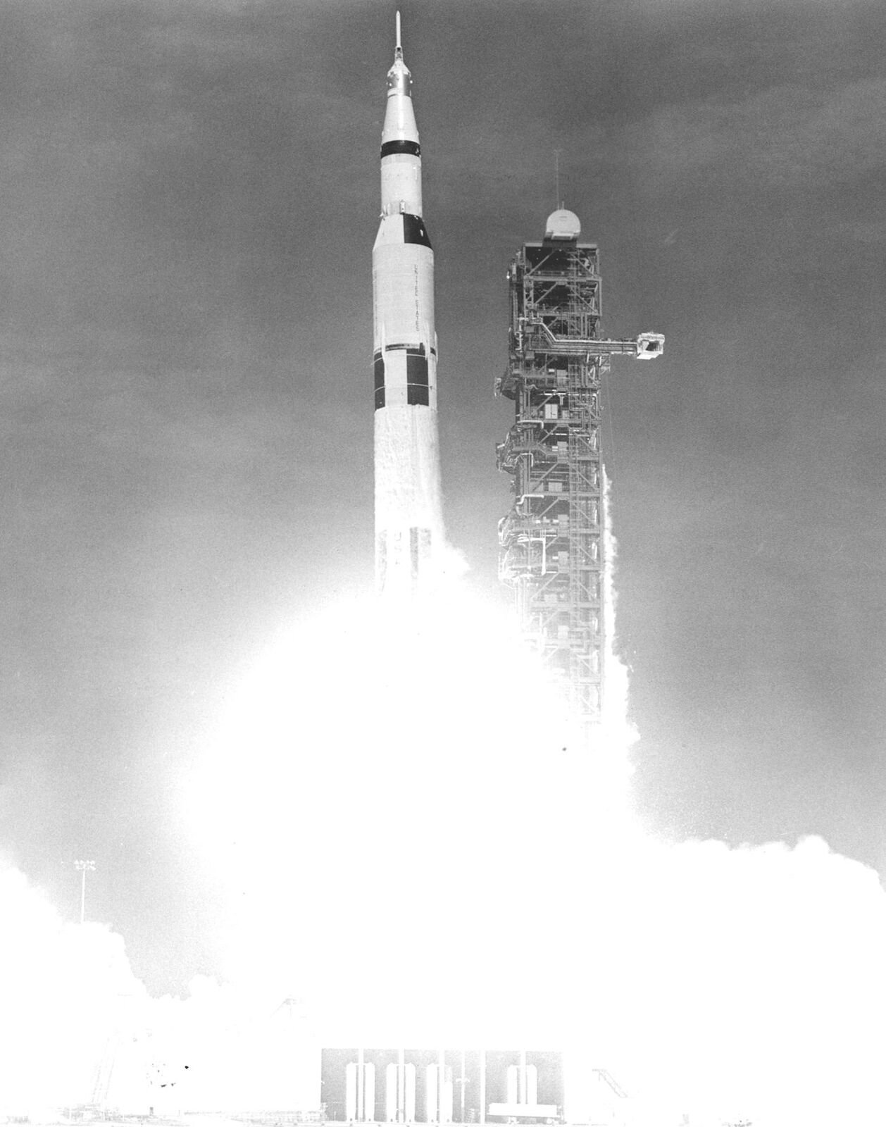 Foguete Saturn V decolando em preto e branco com uma enorme nuvem de fumaça